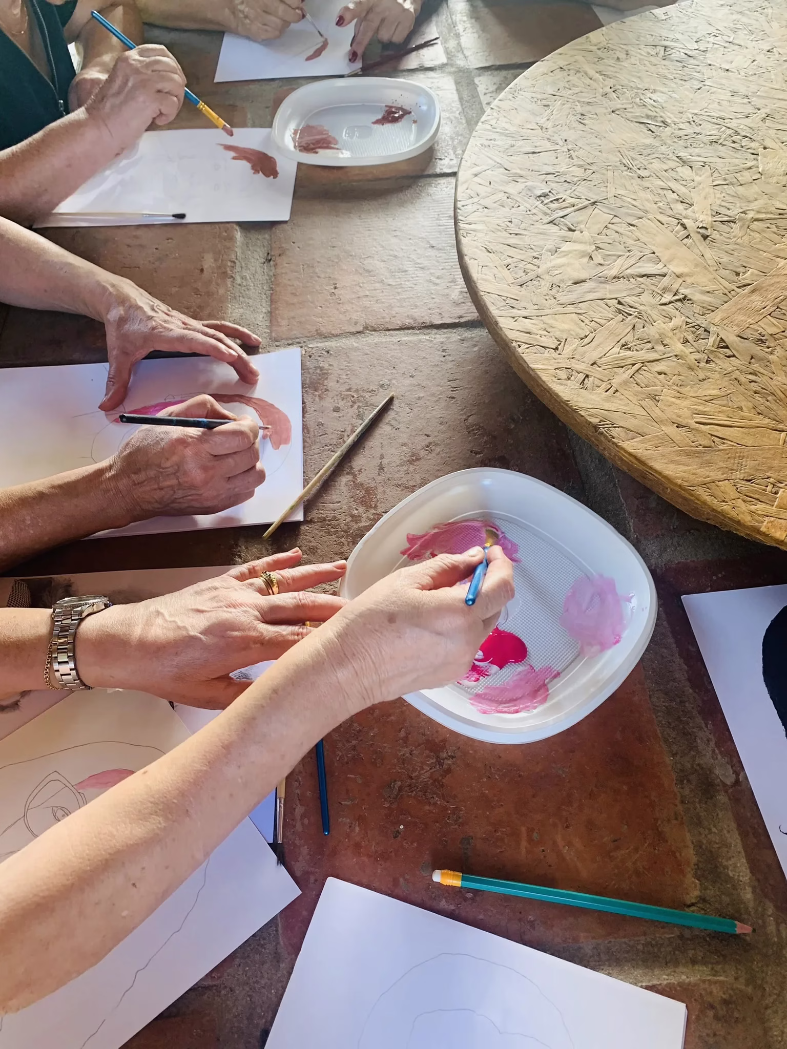 Imagem de adultos a pintarem com guaches durante uma oficina de pintura na Quinta da Ponte